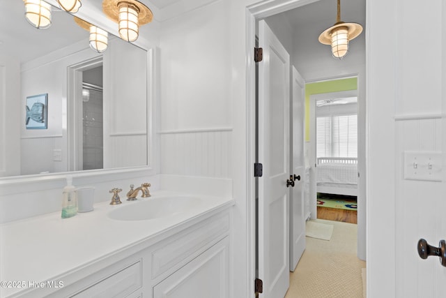 6615 W Beach Dr, Oak Island, NC 28465 - ensuite bathroom with vanity, a wainscoted wall, and tile patterned flooring
