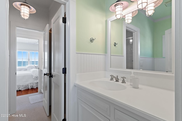 6615 W Beach Dr, Oak Island, NC 28465 - ensuite bathroom featuring vanity, wainscoting, tile patterned floors, and a water view