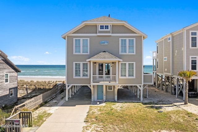 6615 W Beach Dr, Oak Island, NC 28465 - raised beach house with a carport, driveway, and view of water and beach