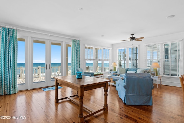 6615 W Beach Dr, Oak Island, NC 28465 - living area featuring wood-type flooring, a ceiling fan, a water view, and french doors