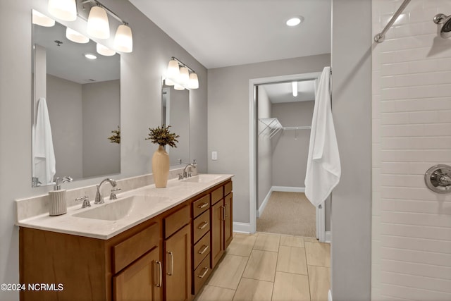 bathroom with walk in shower, vanity, and tile patterned floors