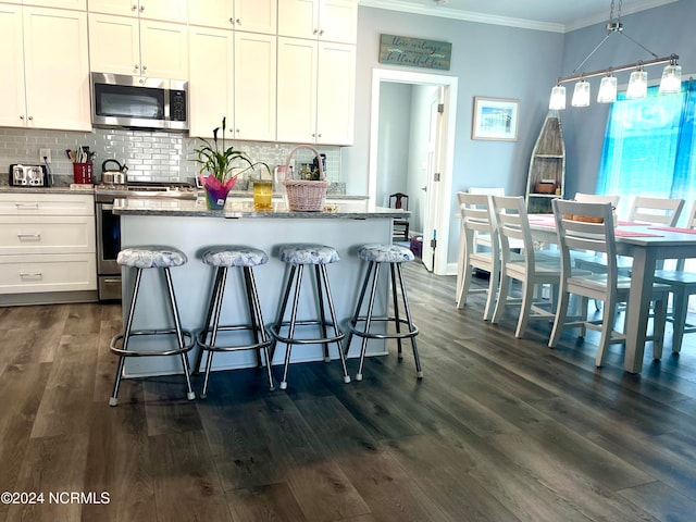 kitchen featuring white cabinets, appliances with stainless steel finishes, and dark hardwood / wood-style floors