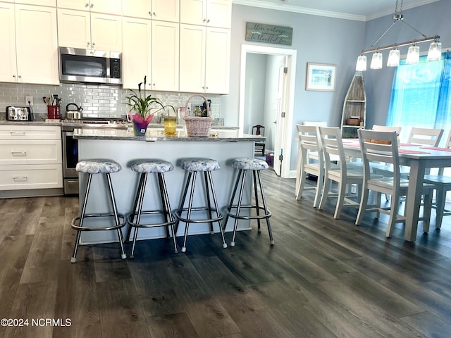 113 Evergreen Ln, Pine Knoll Shores, NC 28512 - kitchen featuring stainless steel appliances, ornamental molding, decorative backsplash, dark wood-style flooring, and a kitchen island