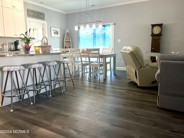 113 Evergreen Ln, Pine Knoll Shores, NC 28512 - dining space featuring dark wood-style flooring and crown molding
