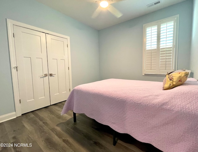 bedroom with ceiling fan, dark wood-type flooring, and a closet