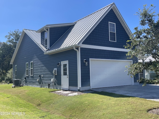 113 Evergreen Ln, Pine Knoll Shores, NC 28512 - view of property exterior with a garage, driveway, a yard, metal roof, and central air condition unit