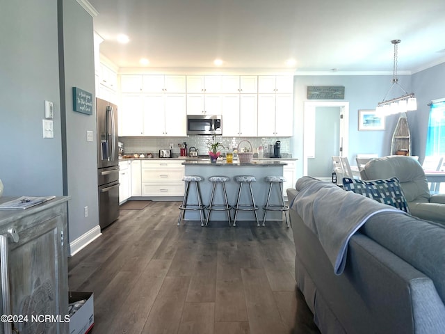 kitchen with stainless steel appliances, white cabinets, and hanging light fixtures