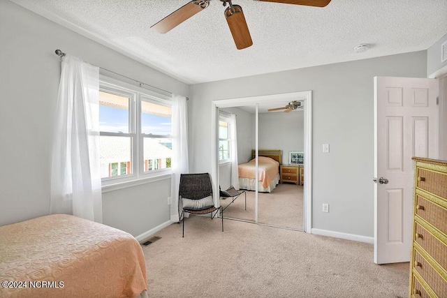 113 Scallop Ln, Carolina Beach, NC 28428 - bedroom with a closet, light colored carpet, a textured ceiling, and a ceiling fan