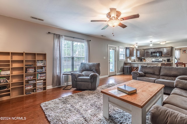 living room featuring ceiling fan and hardwood / wood-style flooring