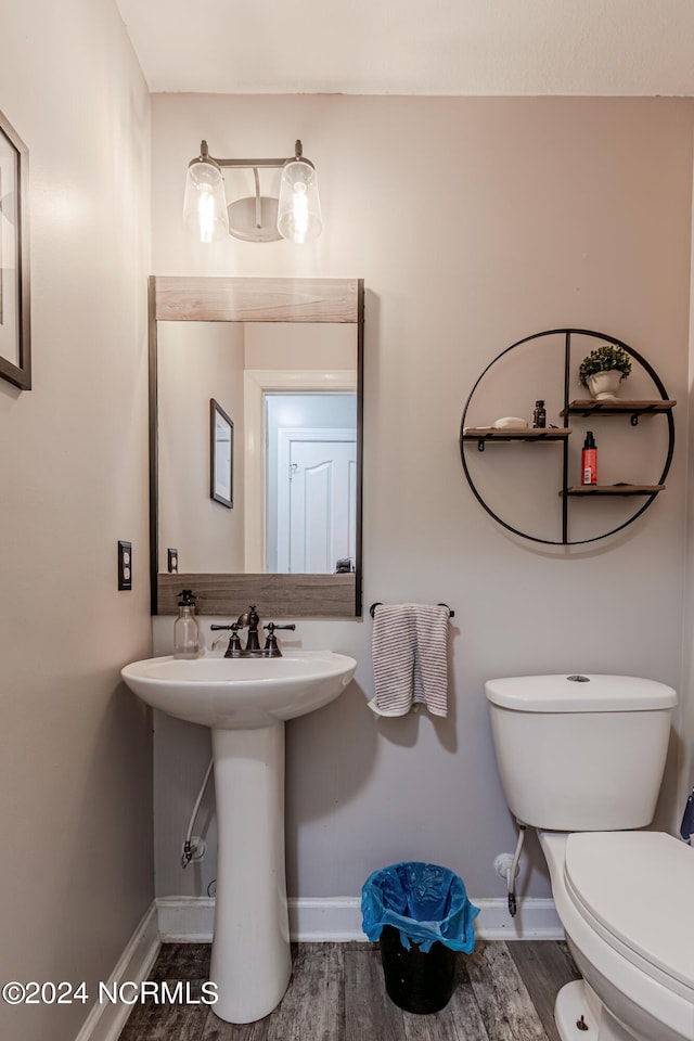 bathroom with toilet, sink, and hardwood / wood-style flooring