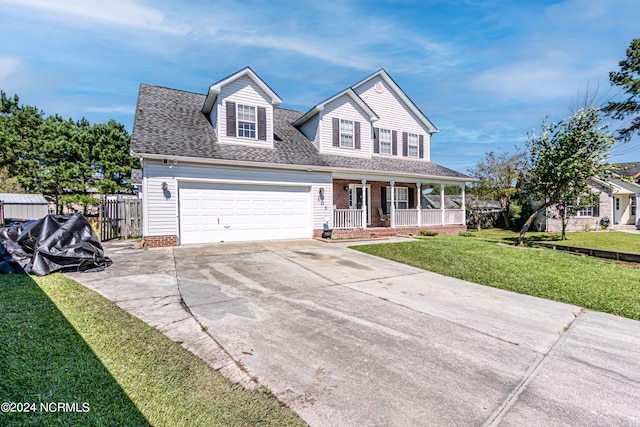 view of front of home featuring a front yard, a garage, and covered porch