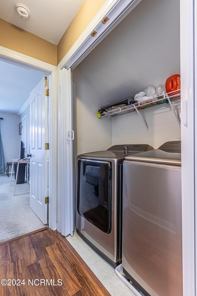 laundry area featuring washer and clothes dryer and light wood-type flooring