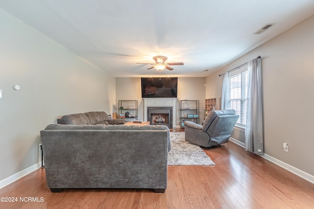 living room featuring wood-type flooring and ceiling fan