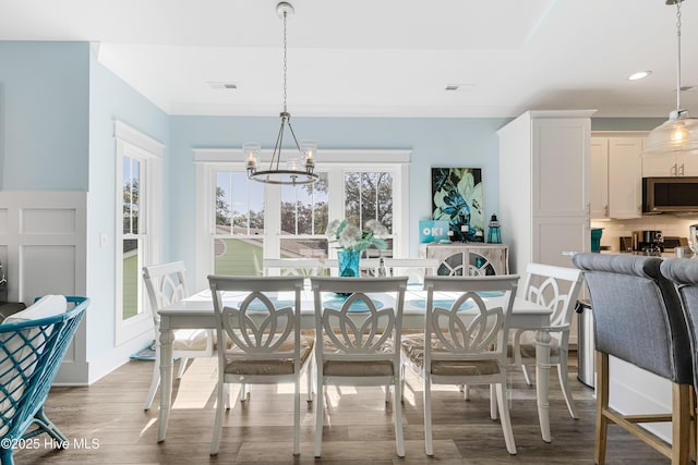 dining space featuring an inviting chandelier, wood finished floors, visible vents, and recessed lighting
