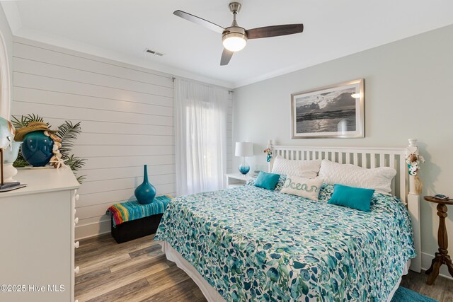 bedroom with visible vents, a ceiling fan, and wood finished floors