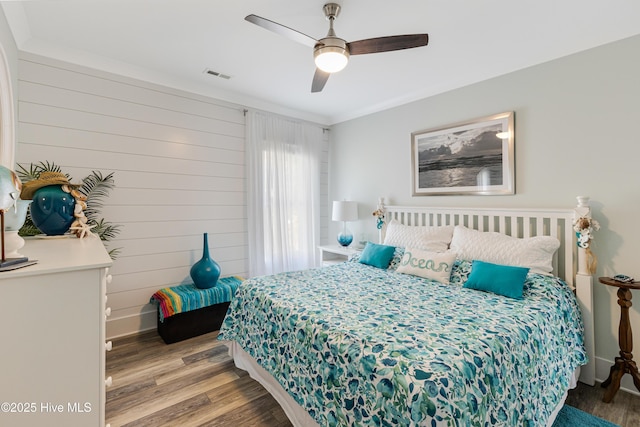 bedroom featuring visible vents, a ceiling fan, and wood finished floors