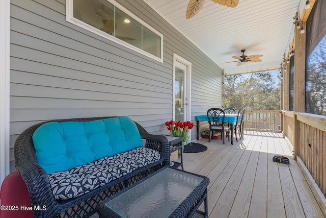 wooden deck featuring outdoor dining space and ceiling fan