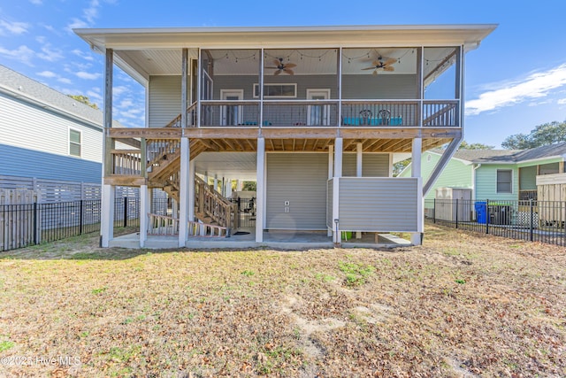 rear view of property with stairway, ceiling fan, a fenced backyard, and a yard