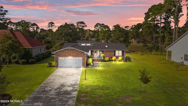 view of front of house with brick siding, driveway, a front yard, and a garage