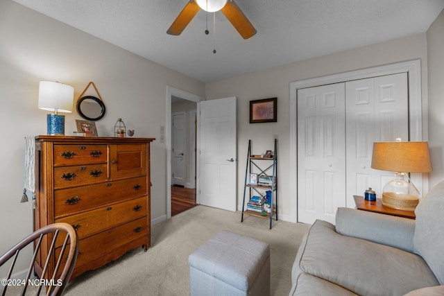 sitting room with light carpet, a textured ceiling, and ceiling fan