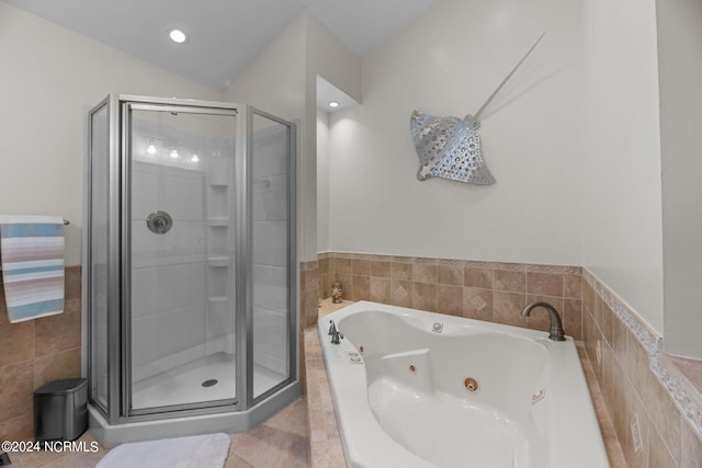 bathroom featuring vaulted ceiling, separate shower and tub, and tile patterned floors