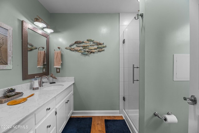 bathroom with vanity, a shower with shower door, and hardwood / wood-style floors