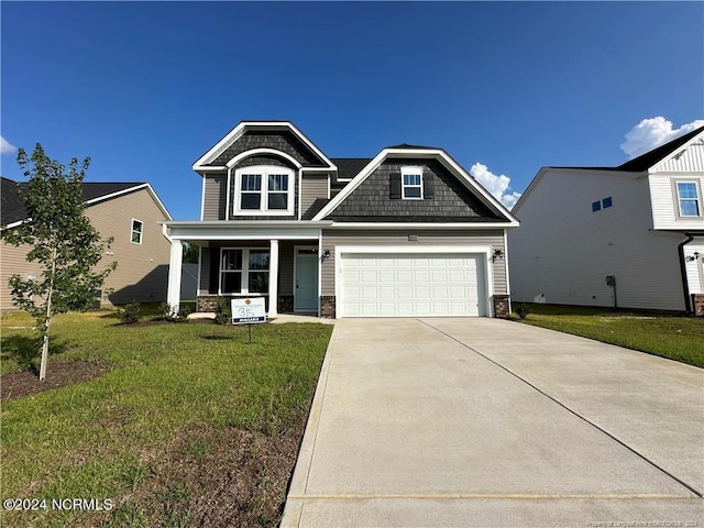 craftsman-style house featuring covered porch and a front yard