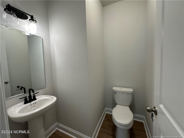 bathroom with hardwood / wood-style flooring, sink, and toilet