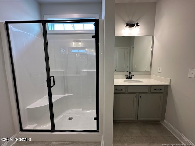 bathroom with vanity, a shower with shower door, and tile patterned flooring