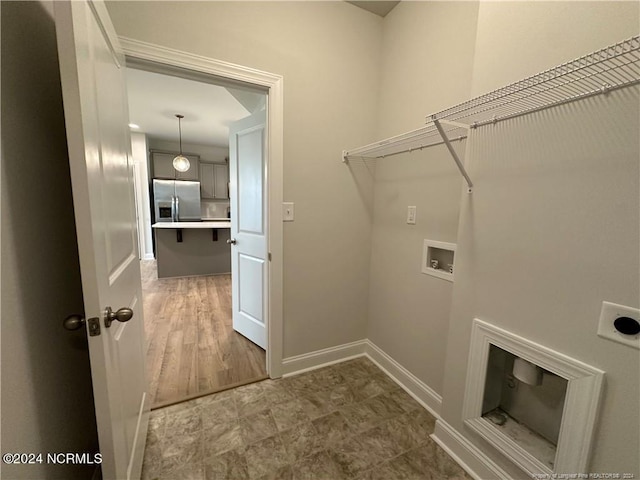 clothes washing area featuring washer hookup, hookup for an electric dryer, and hardwood / wood-style flooring