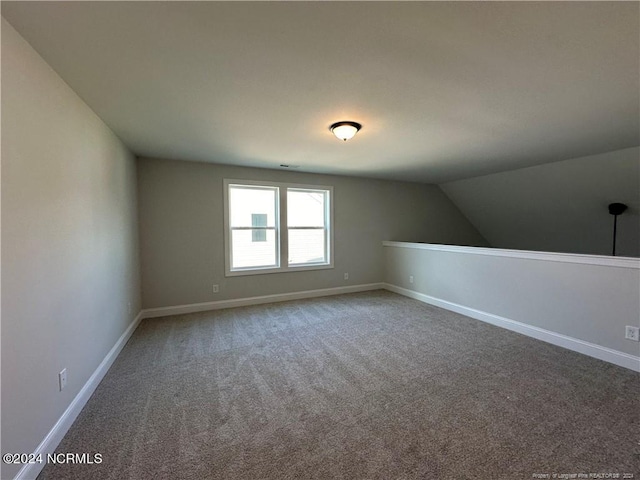 additional living space featuring lofted ceiling and carpet flooring