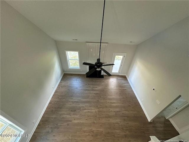 unfurnished dining area featuring ceiling fan and dark hardwood / wood-style flooring