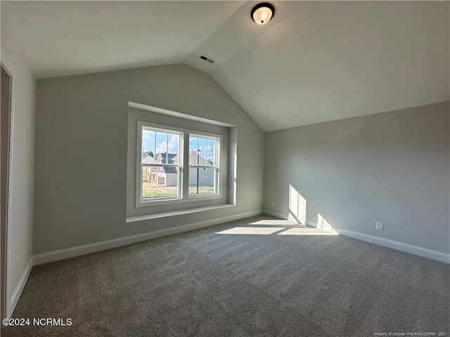 bonus room with dark carpet and lofted ceiling