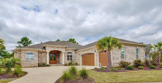 8711 Compass Pointe W Wynd Wynd NE, Leland, NC 28451 - view of front facade with a garage, a front lawn, brick siding, a shingled roof, and driveway