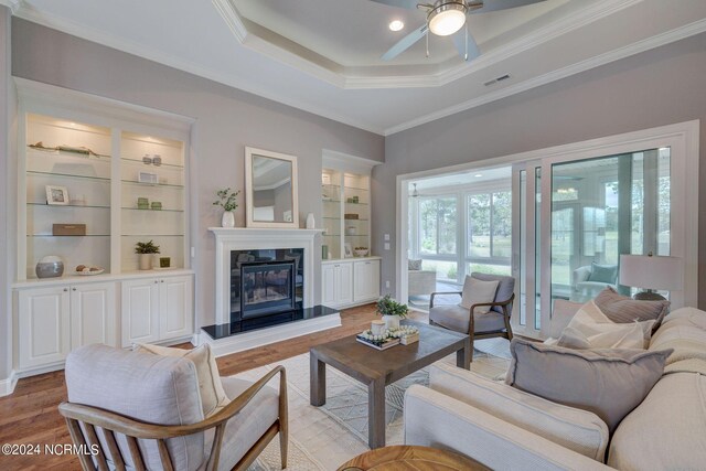 8711 Compass Pointe W Wynd Wynd NE, Leland, NC 28451 - living room featuring ceiling fan, a raised ceiling, a premium fireplace, light wood-type flooring, and visible vents