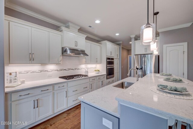 8711 Compass Pointe W Wynd Wynd NE, Leland, NC 28451 - kitchen with crown molding, under cabinet range hood, white cabinets, a sink, and appliances with stainless steel finishes
