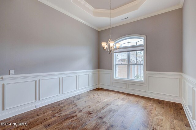 8711 Compass Pointe W Wynd Wynd NE, Leland, NC 28451 - spare room with a notable chandelier, wainscoting, a raised ceiling, wood finished floors, and visible vents