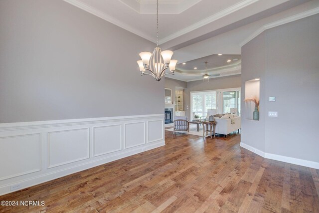 8711 Compass Pointe W Wynd Wynd NE, Leland, NC 28451 - dining area featuring crown molding, ceiling fan with notable chandelier, a tray ceiling, recessed lighting, and light wood-style flooring