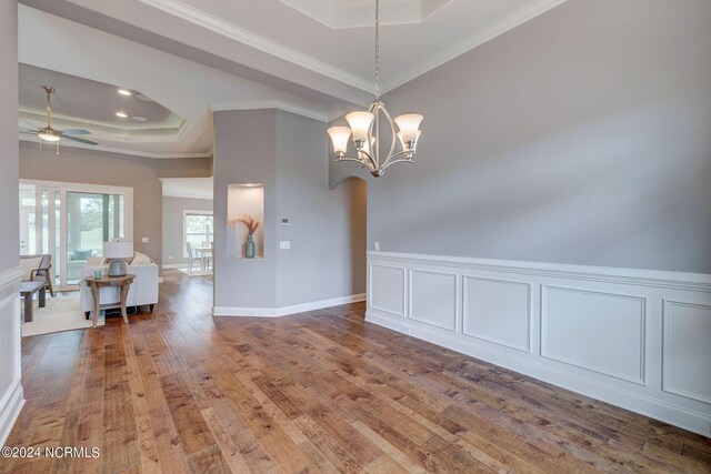 8711 Compass Pointe W Wynd Wynd NE, Leland, NC 28451 - dining room featuring crown molding, arched walkways, wood finished floors, ceiling fan with notable chandelier, and a tray ceiling