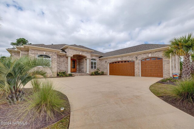 8711 Compass Pointe W Wynd Wynd NE, Leland, NC 28451 - view of front of house with brick siding, a garage, a shingled roof, and concrete driveway