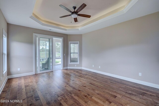 8711 Compass Pointe W Wynd Wynd NE, Leland, NC 28451 - spare room featuring baseboards, ceiling fan, wood finished floors, and a raised ceiling