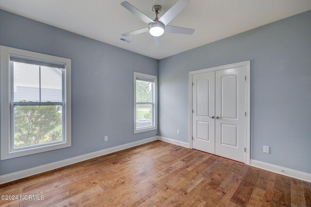 8711 Compass Pointe W Wynd Wynd NE, Leland, NC 28451 - unfurnished bedroom featuring ceiling fan, visible vents, wood finished floors, baseboards, and a closet