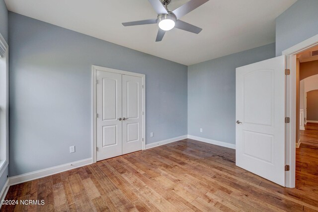 8711 Compass Pointe W Wynd Wynd NE, Leland, NC 28451 - unfurnished bedroom featuring baseboards, wood finished floors, and a closet