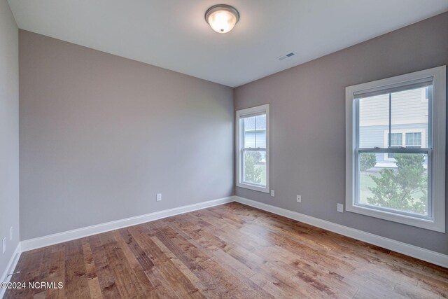 8711 Compass Pointe W Wynd Wynd NE, Leland, NC 28451 - spare room with baseboards, visible vents, and wood finished floors