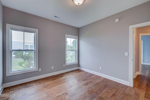 8711 Compass Pointe W Wynd Wynd NE, Leland, NC 28451 - empty room featuring visible vents, baseboards, and wood finished floors