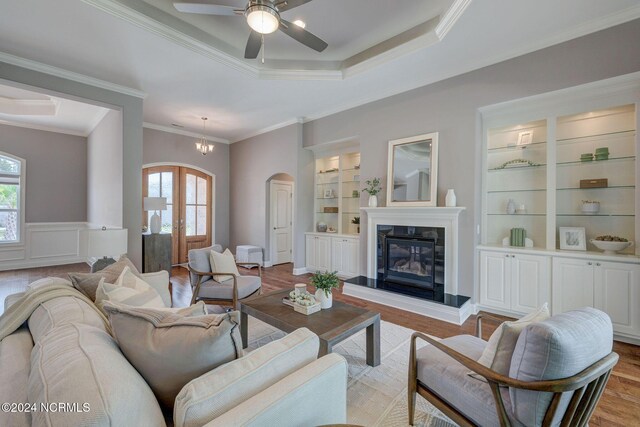 8711 Compass Pointe W Wynd Wynd NE, Leland, NC 28451 - living area with arched walkways, a raised ceiling, wood finished floors, and a healthy amount of sunlight