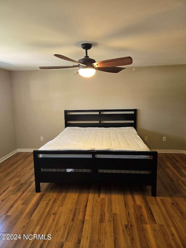 unfurnished bedroom featuring ceiling fan and dark hardwood / wood-style flooring