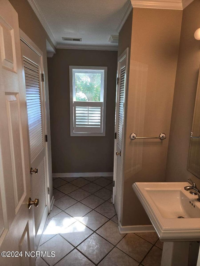 bathroom with ornamental molding and tile patterned floors