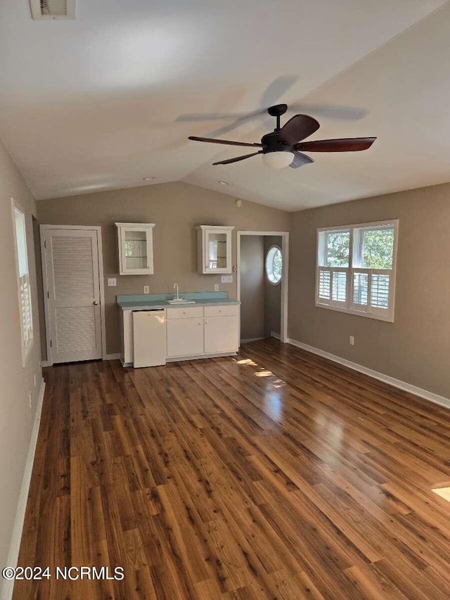 unfurnished living room featuring vaulted ceiling, dark hardwood / wood-style flooring, ceiling fan, and sink