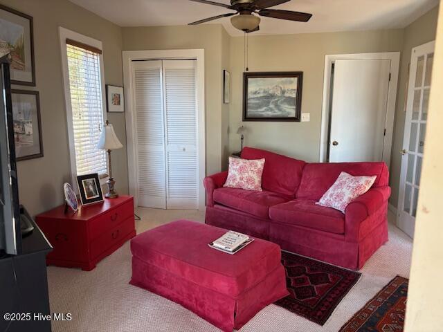 carpeted living room featuring ceiling fan